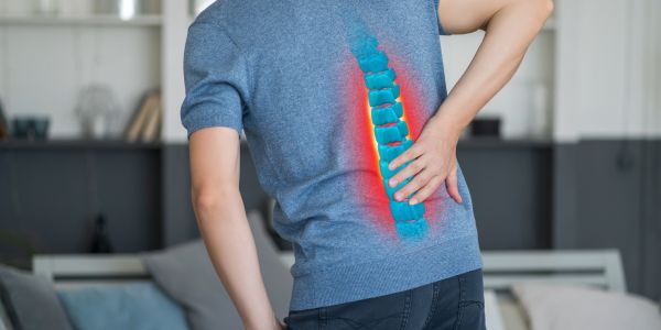 Doctor explaining herniated disc causes and treatment to a patient with back pain